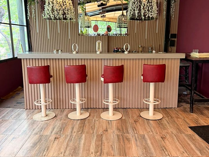 La barra del salón de eventos, con banquetas rojas