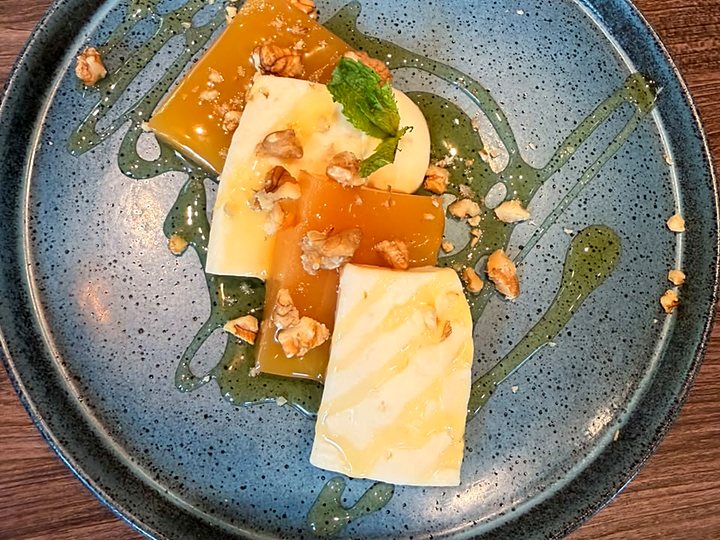 Queso y dulce con nueces y almíbar, en plato de cerámica azul