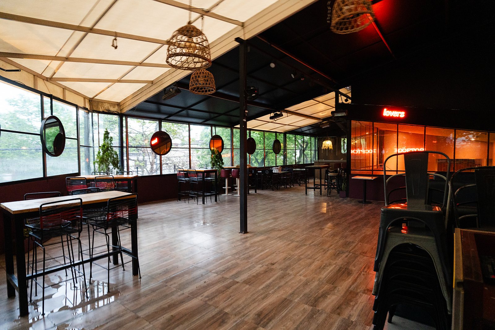 El Rooftop listo para un evento: mesas altas, piso de madera y ventanales
